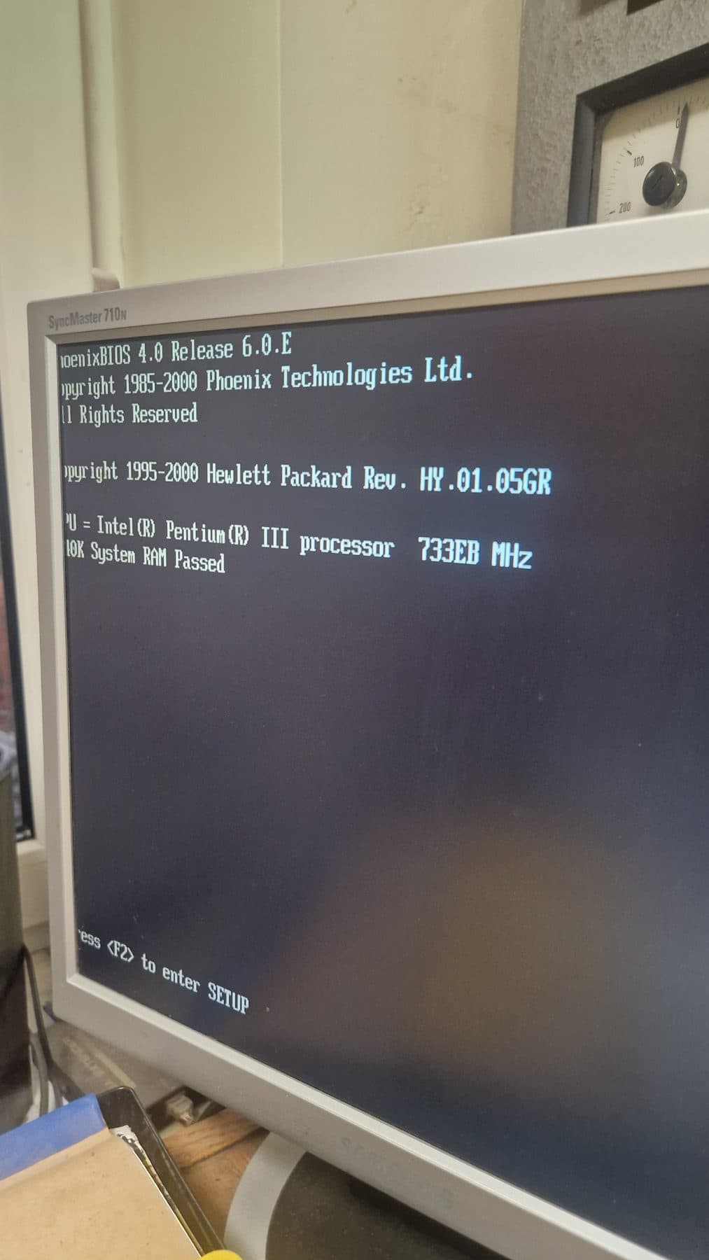 Komputer sterujący z BIOS-em z początku wieku obok analogowego miernika